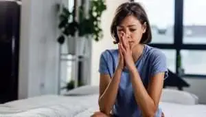 woman in deep thoughts holding her hands together in a prayer position touching her face