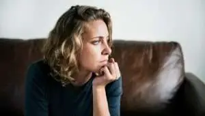 worried woman looking in the distance while supporting her head with the hand