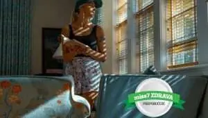 young woman with the hat holding-a book and looking thru the window of-an apartment